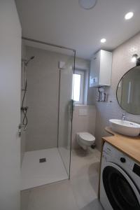 een badkamer met een douche, een toilet en een wastafel bij Apartments Emona FREE Parking-sauna-gym in Ljubljana