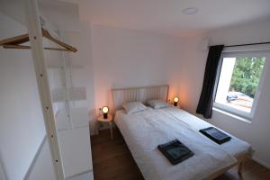 een slaapkamer met een groot bed en een raam bij Apartments Emona FREE Parking-sauna-gym in Ljubljana