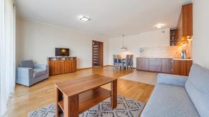 a living room with a table and a couch at Apartamenty Sun & Snow Rozewie in Jastrzębia Góra