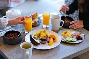 a table topped with plates of breakfast foods and orange juice at Thalazur Arcachon in Arcachon