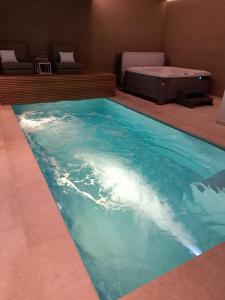 The Newport Lodge - incl Breakfast, 3u Wellness and Ebike في نيوبورت: حمام سباحة بمياه زرقاء في الغرفة