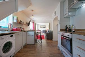 a kitchen with a washer and dryer in it at Garden Oasis in Margate