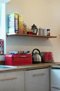a kitchen with a counter top with books and dishes at Garden Oasis in Margate