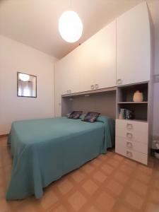 コスタ・レイにあるNuova Valmar Trilo Mimosaのベッドルーム(緑のベッド1台、白いキャビネット付)
