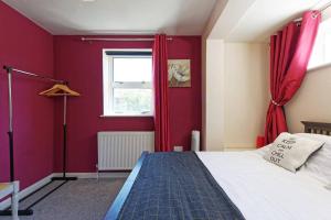 a red bedroom with a bed and a window at Garden Oasis in Margate