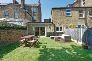 un jardín con una mesa de madera y sillas en un patio en Garden Oasis, en Margate