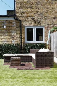 two wicker benches sitting in front of a building at Garden Oasis in Margate