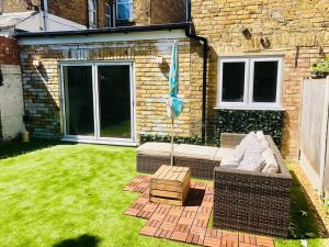 a backyard with a couch and a table in the grass at Garden Oasis in Margate