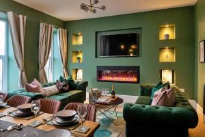 a living room with green furniture and a fireplace at Finest Retreats - Peace Retreats Penthouse in Pwllheli