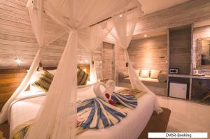 a bedroom with a bed with a mosquito net at Dayung Villas By Reccoma in Nusa Lembongan