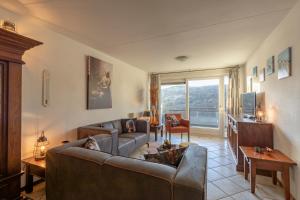 ein Wohnzimmer mit einem Sofa und einem Tisch in der Unterkunft Wijde Blick appartement 210 Callantsoog in Callantsoog