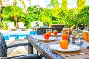 - une table extérieure avec des assiettes de fruits et des verres de jus d'orange dans l'établissement Villa Lilly Rose, à Pólis Chrysochoús