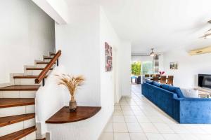 - un salon avec un canapé bleu et un escalier dans l'établissement Villa Lilly Rose, à Pólis Chrysochoús