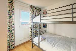 1 dormitorio con 2 literas y ventana en APARTAMENT PAU CASALS, 2 min walk from the sea & sea view, en Lloret de Mar