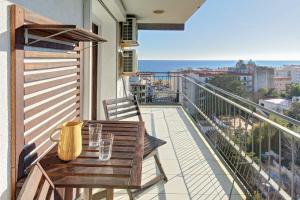 balcón con mesa de madera y sillas en APARTAMENT PAU CASALS, 2 min walk from the sea & sea view, en Lloret de Mar