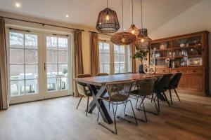 a dining room with a wooden table and chairs at De Kroft Beach Residences Noordwijk aan Zee in Noordwijk