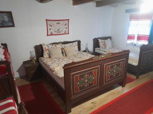 a bedroom with a wooden bed with pillows at Székelyföld ,Siklódi Kő Vendégház, Tornácosház in Bartoştana