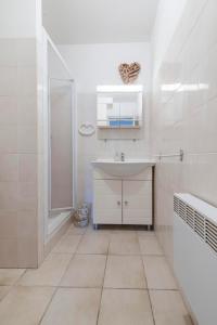 a white bathroom with a sink and a shower at Le Petit Colliourenc in Collioure