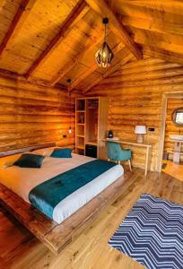 a bedroom with a large bed in a wooden cabin at Complex Bosco in Borşa