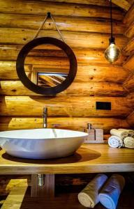 La salle de bains est pourvue d'un lavabo blanc et d'un mur en bois. dans l'établissement Complex Bosco, à Borşa