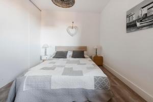 a bedroom with a large bed in a white room at Le Petit Colliourenc in Collioure