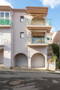biały budynek apartamentowy z balkonem i garażem w obiekcie Le Petit Colliourenc - Apt climatisé avec terrasse w mieście Collioure