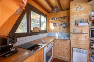 レ・ザングルにあるChalet des Pyramidesのキッチン(木製キャビネット付)、窓