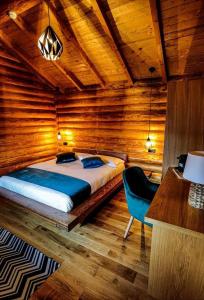 um quarto com uma cama e uma cadeira azul em Complex Bosco em Borşa