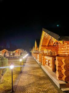 una fila de edificios de madera con luces encendidas por la noche en Complex Bosco en Borşa