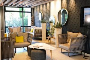 a lobby with chairs and a table and a mirror at Thalazur Arcachon in Arcachon