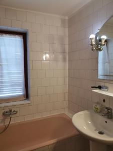 łazienka z wanną, umywalką i oknem w obiekcie Cabana Fantanita cu Brazi w mieście Poiana Brașov