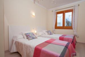 2 Betten in einem weißen Zimmer mit Fenster in der Unterkunft Gran Canal in Alcúdia