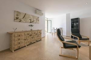 阿爾科斯－德拉弗龍特拉的住宿－Boliches，客厅配有两把椅子和木制梳妆台