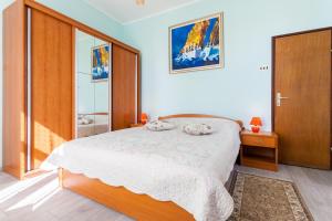 a bedroom with a large bed and a sliding glass door at Rooms Marija in Malinska