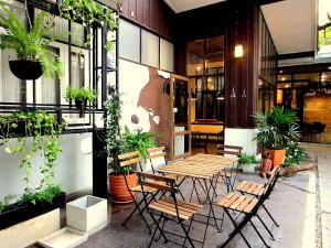 a patio with a table and chairs and plants at Chiang Mai D Hostel in Chiang Mai