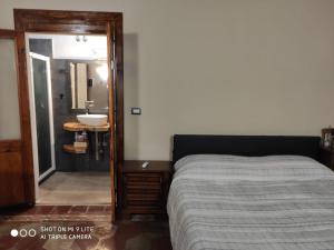 a bedroom with a bed and a bathroom with a sink at ZED-HOUSE in Nizza Monferrato