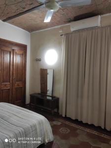 a bedroom with a bed and a curtain and a dresser at ZED-HOUSE in Nizza Monferrato