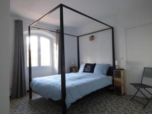 a bedroom with a black canopy bed with a window at Apartment Cézanne mit geheiztem Pool und Privatgarten in Châteauneuf