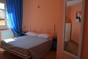 コモにあるVacanze Casa di Trizziのベッドルーム1室(青いカーテンと鏡付きのベッド1台付)