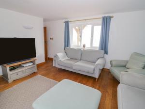 a living room with two couches and a flat screen tv at Fairview House in Kidderminster