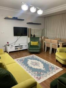 a living room with a yellow couch and a tv at 2 bedroom 5 bed peaceful calm full kitchen,all items available Luxury And relax in Istanbul