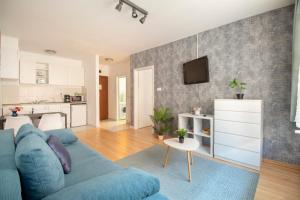 sala de estar con sofá azul y cocina en Prince Apartments en Budapest