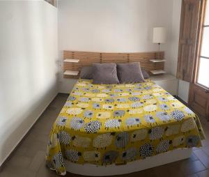 ein Schlafzimmer mit einem großen Bett und einer gelben Decke in der Unterkunft Apartamento de diseño cerca de tren, playa y BCN in Masnou