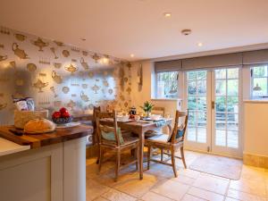 a kitchen and dining room with a table and chairs at Pineapple Spa Cottage in Stow on the Wold