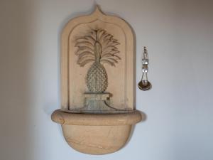 posąg ananasa na ścianie w obiekcie Pineapple Spa Cottage w mieście Stow on the Wold