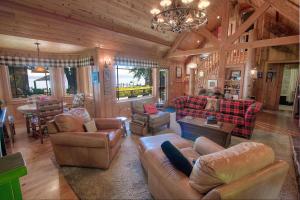 a living room with couches and chairs in a cabin at Lakefront History cabin in Homewood
