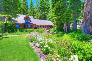 a house with a garden with flowers in front of it at Lakefront History cabin in Homewood