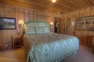 a bedroom with a bed in a room with wooden walls at Lakefront History cabin in Homewood