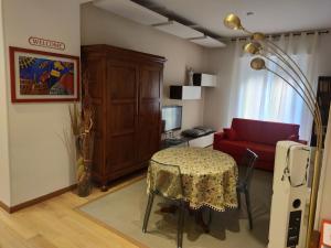 uma sala de estar com uma mesa e um sofá vermelho em Appartamento EmmeRosa, centro città, parcheggio em Verona
