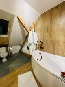 a bathroom with a white tub and a toilet at Apartamenty Happy & Relax in Bielsko-Biała